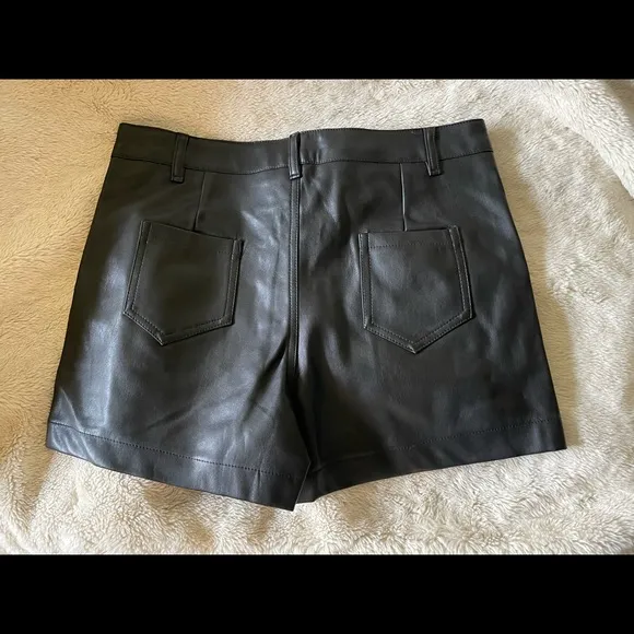 Design by Korea, approx 28” NWOT black synthetic leather short w/ front pockets.