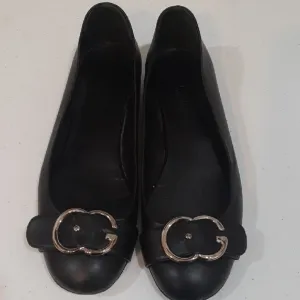 Gucci Black Leather Flats with Silver Buckle.