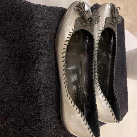 ISABELLA FIORE “Lovely Bis” silver flats with black stitching and tassel