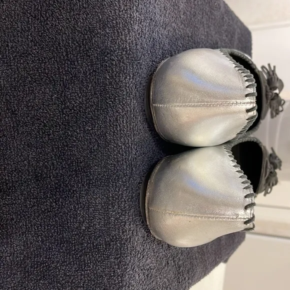 ISABELLA FIORE “Lovely Bis” silver flats with black stitching and tassel