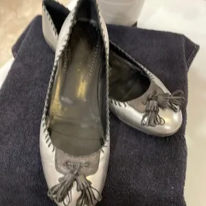 ISABELLA FIORE “Lovely Bis” silver flats with black stitching and tassel
