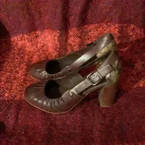 Women’s brown leather heels with snakeskin.